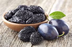 Image of a bowl, of prunes, which are high in vitamins, almost blue to black in colour and also, they are used as a evening snack